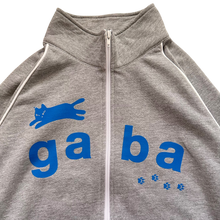 Load image into Gallery viewer, A close-up of a heather gray zip-up hoodie featuring a bold blue 'ga ba' graphic and a blue leaping cat logo on the chest, with white piping along the shoulders and a white zipper.
